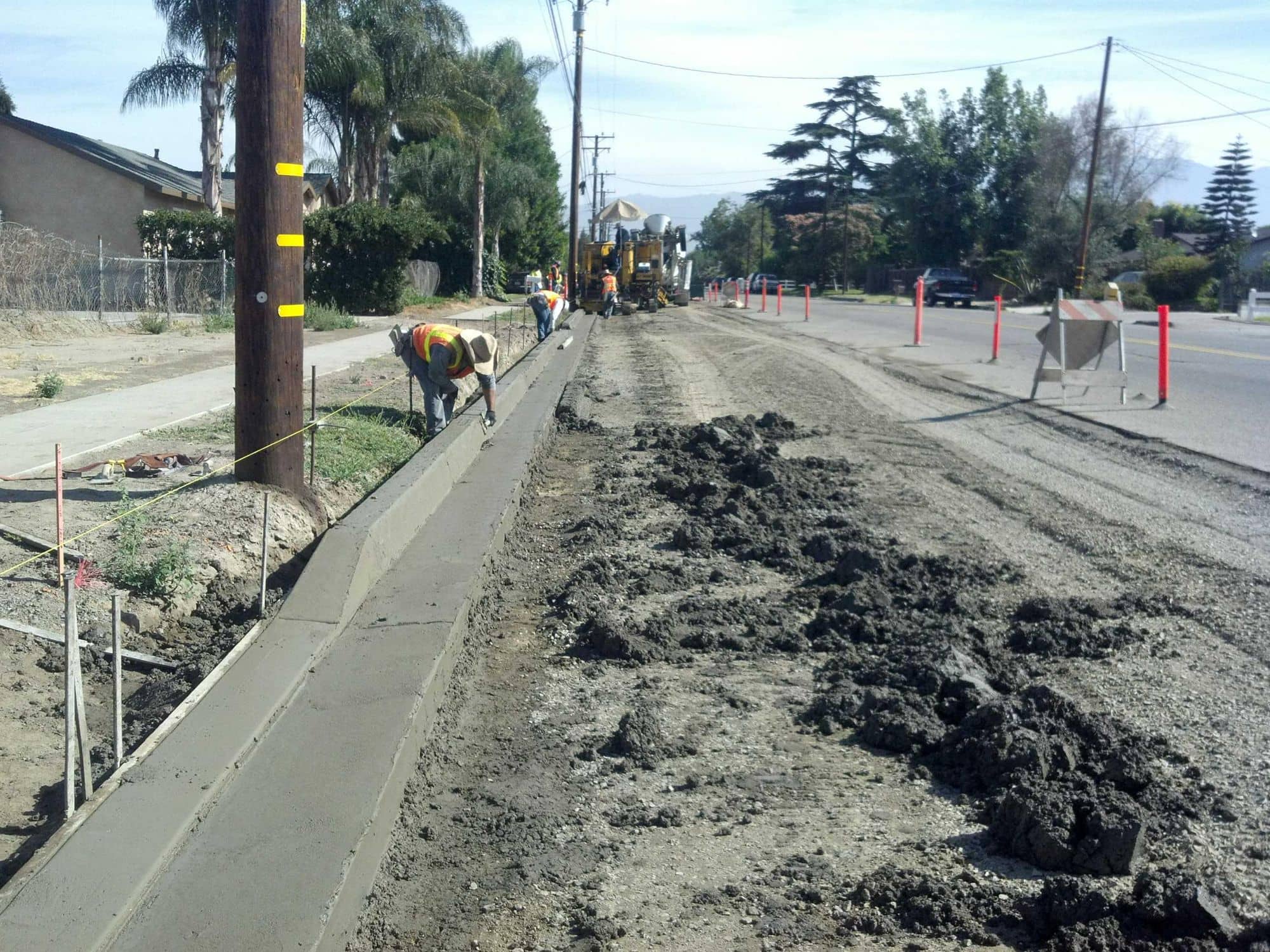 New concrete curb and gutter line running along a roadside under construction