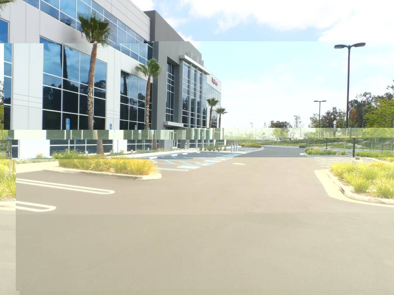 Driveway entrance beside a glass office building after resurfacing