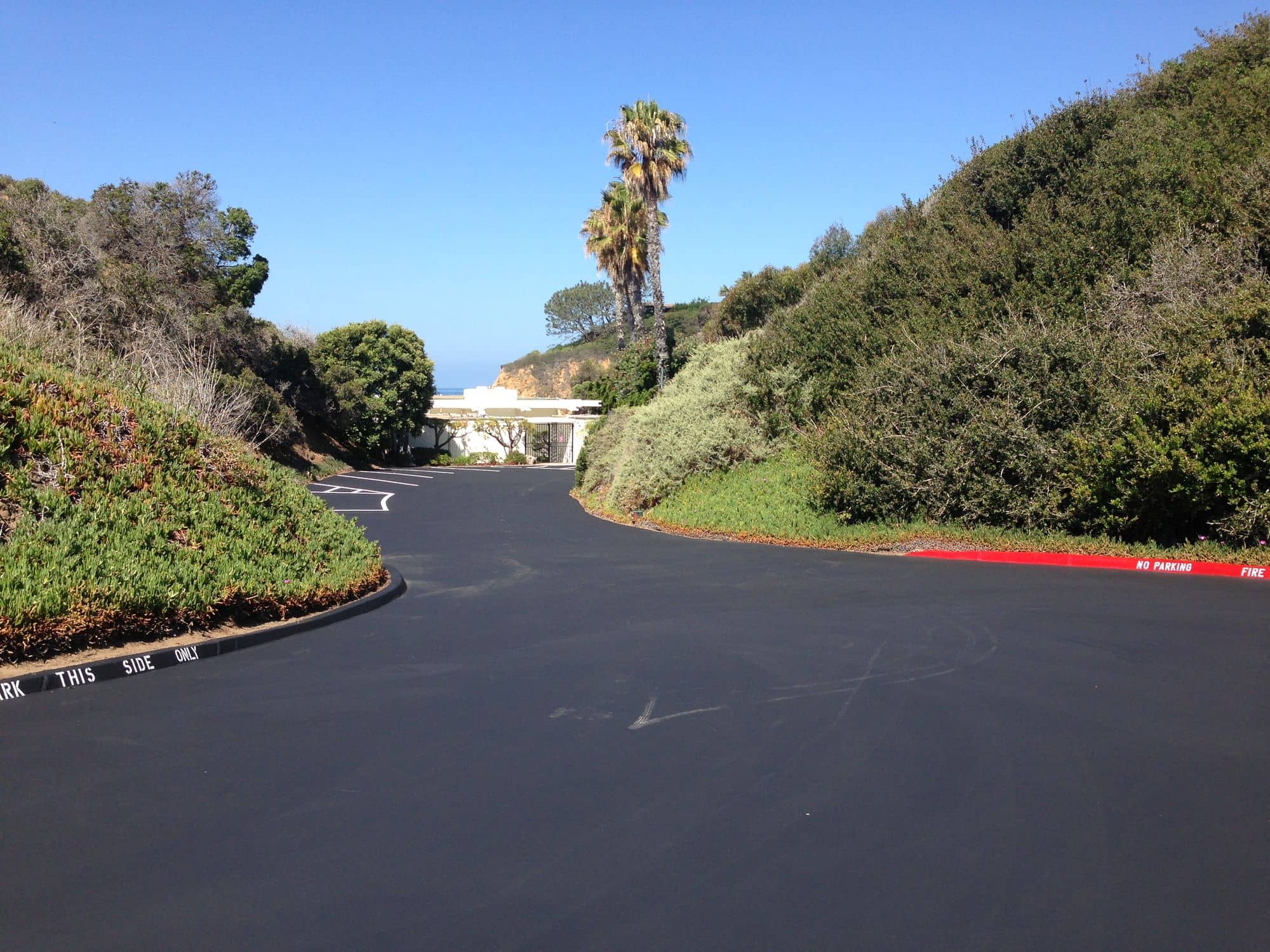 After: the hillside drive finished in uniform black with freshly painted red curbs