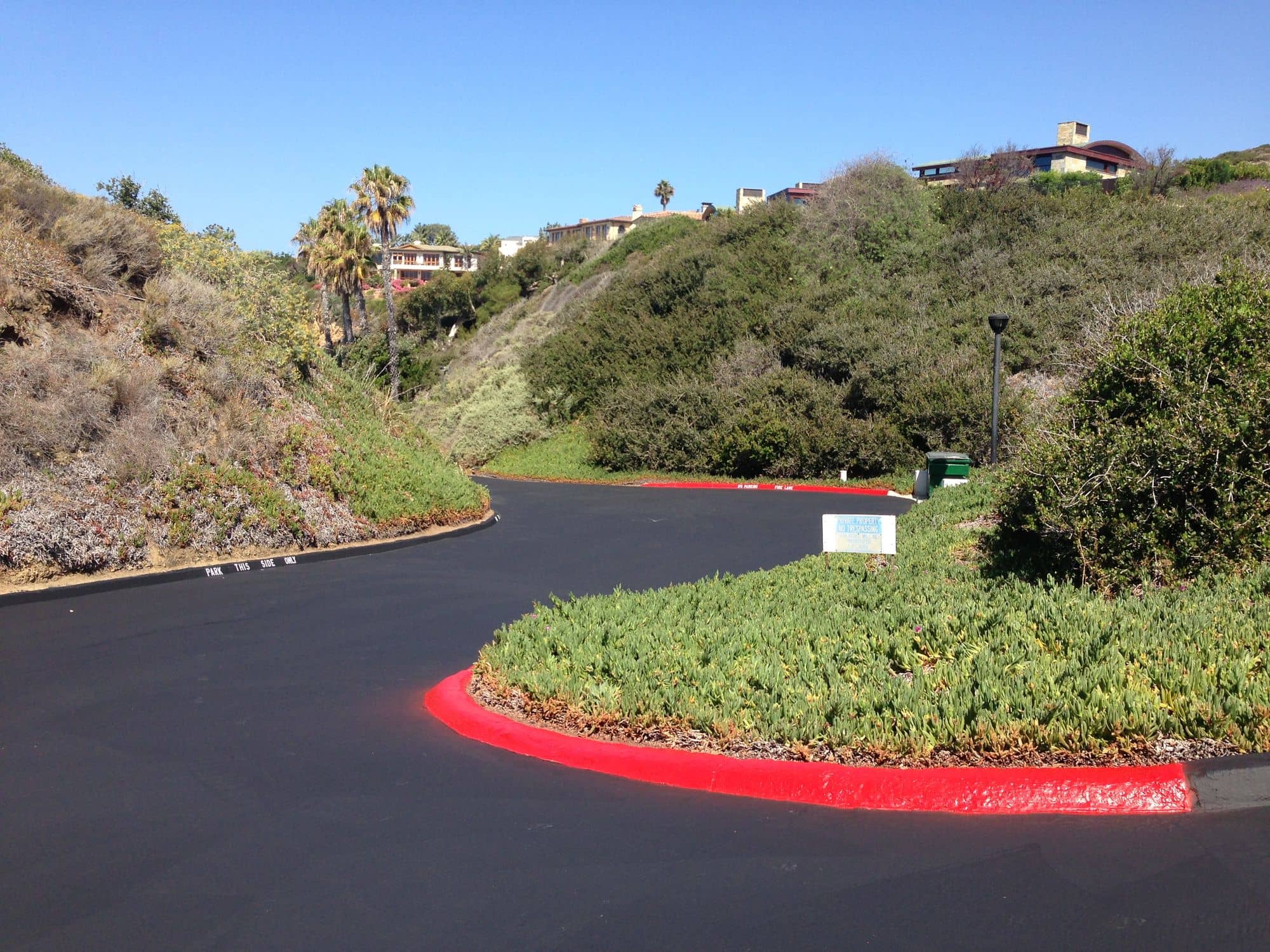 Sealed entry drive curving around a planted island edged in bright red curb paint