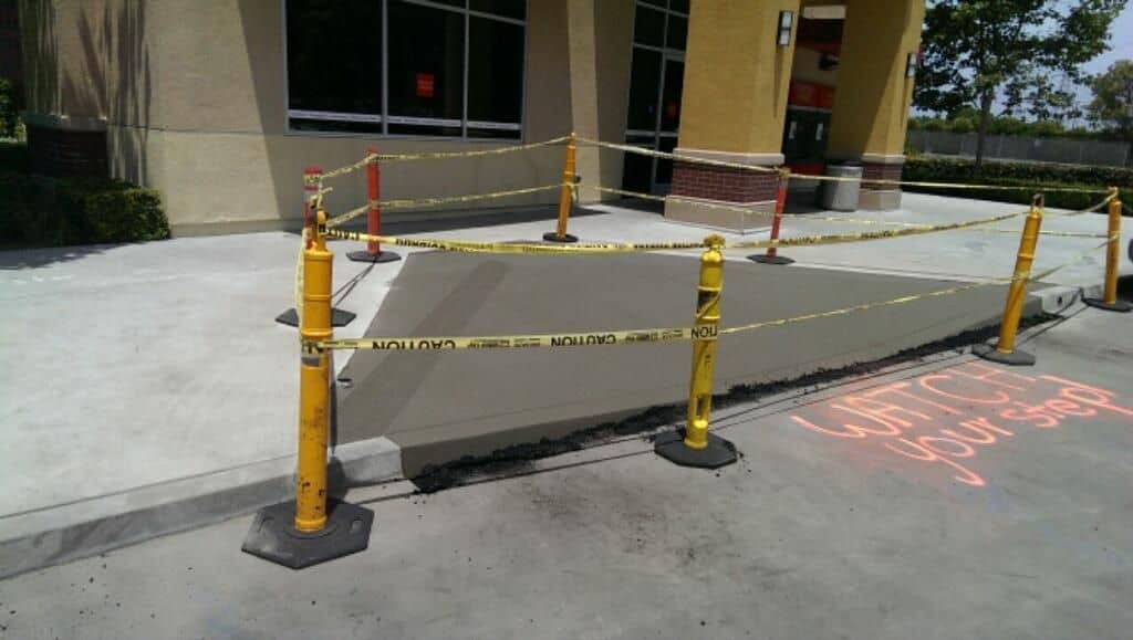 Side view of a new concrete step-down panel cordoned off while it cures